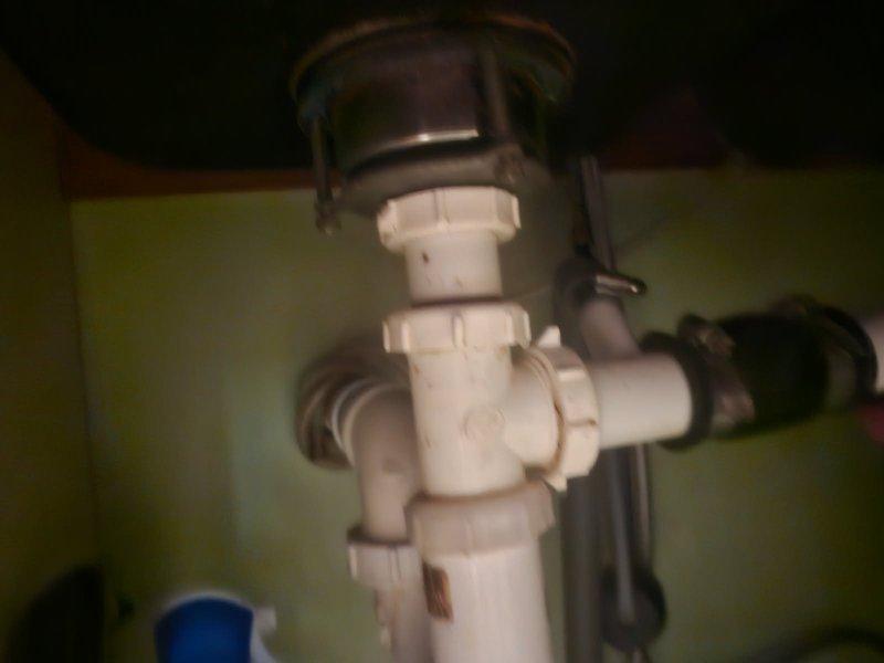 Responded to a kitchen sink drain leak caused by a loose PVC connection under the basin. Upon inspection, found the drain assembly fittings had worked loose and required replacement. Additionally, installed a customer-provided kitchen sink, which necessitated lowering the drain line to accommodate the new fixture's configuration. Replaced the deteriorated PVC drain assembly components, including slip joints and trap fittings, ensuring proper alignment and secure connections. All connections were tested for leaks and confirmed watertight upon completion.