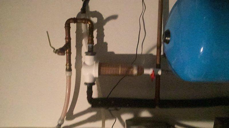 Serviced well water filtration system at pressure tank location in basement. Inspected sediment filter housing which showed significant discoloration and buildup due to extended service interval. Flushed filter housing, replaced dirty cartridge with new filtration media, and verified proper system operation. Provided estimate for installation of main water supply ball valve to improve system serviceability and allow for easier future maintenance shutdowns.