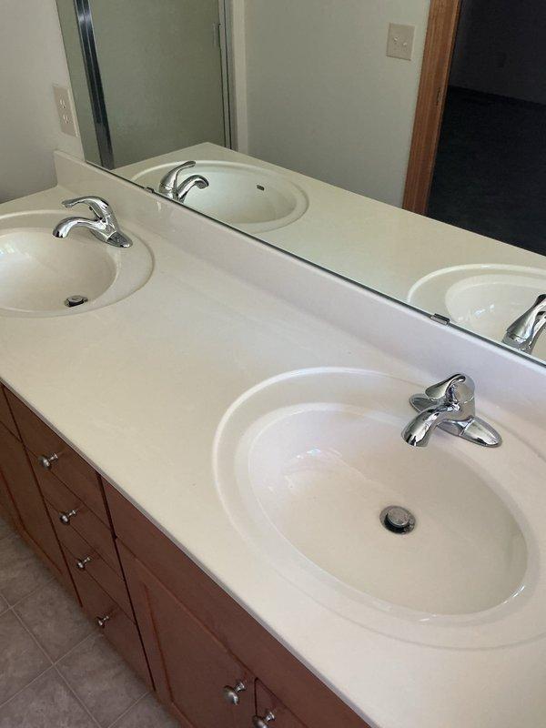 Installed three new chrome vanity faucets with drain stems on double sink bathroom vanity in vacant property. Diagnosed and repaired refrigerator water line leak caused by faulty coupling, replaced defective coupling with new fitting, and restored water supply to appliance. Verified all fixtures operational and confirmed completion of work order items prior to departure.
