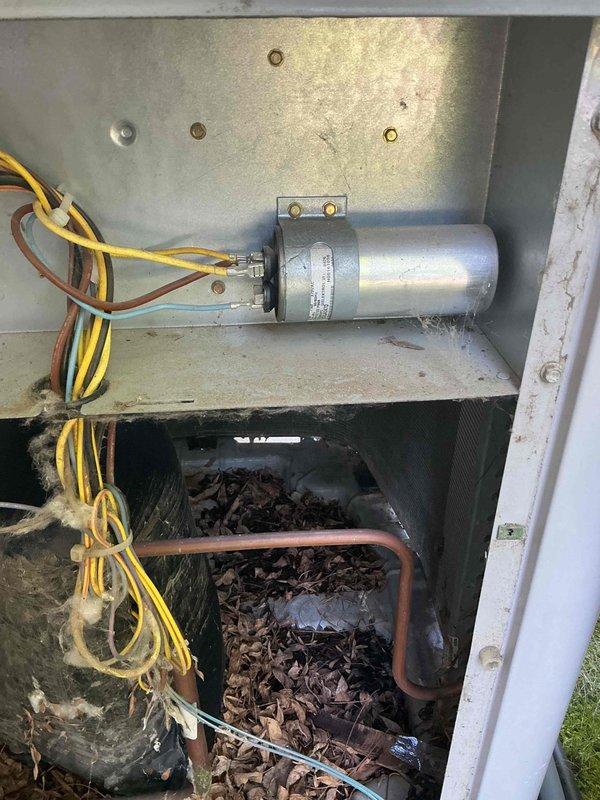 Responded to no cooling complaint on 22-year-old Carrier air conditioning system. Upon arrival, discovered system was completely depleted of refrigerant. Customer reported unit was functioning properly two days prior, indicating a sudden catastrophic leak. Performed thorough inspection of all accessible components including braze joints, service valves, and coil areas. No oil spray or residue found at joints or valves, suggesting leak source is internal to either evaporator or condenser coil. Noted significant debris accumulation in outdoor unit consisting of leaves and organic matter around coil assembly, which may contribute to reduced airflow and system efficiency. 

At customer request, conducted additional evaluation of furnace and heat exchanger to determine viability of complete system replacement versus repair. Visual inspection of heat exchanger revealed potential crack formation beginning in one of the eyelets; however, findings were not definitive enough to warrant immediate