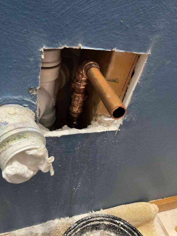 Responded to emergency call for broken pipe under kitchen sink. Upon arrival, found that compression fitting had failed during attempted valve replacement, resulting in fractured copper pipe section. Accessed plumbing system through existing wall opening to assess damage extent. Cut out damaged pipe segment and installed new copper pipe section with proper compression fittings to restore water supply line integrity. Tested system for leaks and verified proper water flow upon completion.