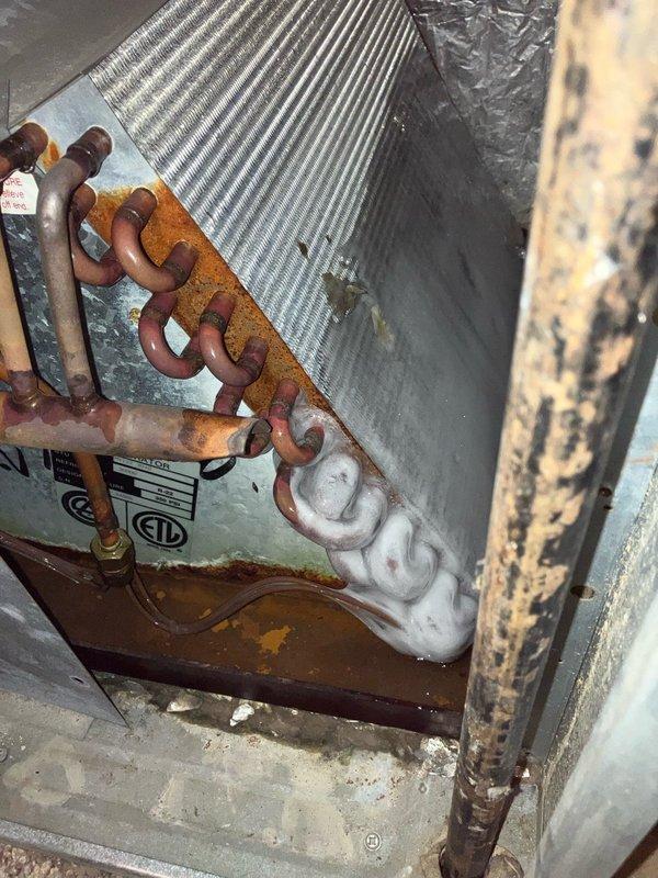 Responded to a no cooling complaint on a 25-year-old residential air conditioning system. Upon arrival, found the indoor evaporator coil partially frozen and confirmed the system was low on R-22 refrigerant. Performed diagnostic testing which revealed inadequate cooling capacity with only a 9°F temperature split across the coil, well below the normal 15-20°F range expected for proper operation. The indoor furnace unit showed significant age-related deterioration with visible rust on copper refrigerant lines and connection points. The outdoor condensing unit was evaluated with digital manifold gauges to verify refrigerant charge and system pressures. Given the system's age (manufactured in 1995), use of obsolete R-22 refrigerant, declining performance, and overall condition of the equipment, recommended system replacement rather than repair. Coordinated with sales team to schedule equipment replacement consultation with homeowner to discuss modern, efficient replacement options.