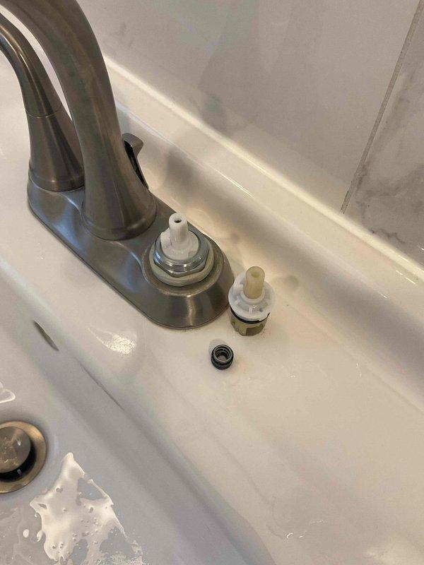 Completed labor-only installation of customer-supplied bathroom faucet assembly on white ceramic countertop sink. Installed dual-handle brushed nickel faucet with high-arc spout, including valve cartridges, mounting hardware, and drain assembly components. Tested system for proper operation and verified no leaks upon completion.