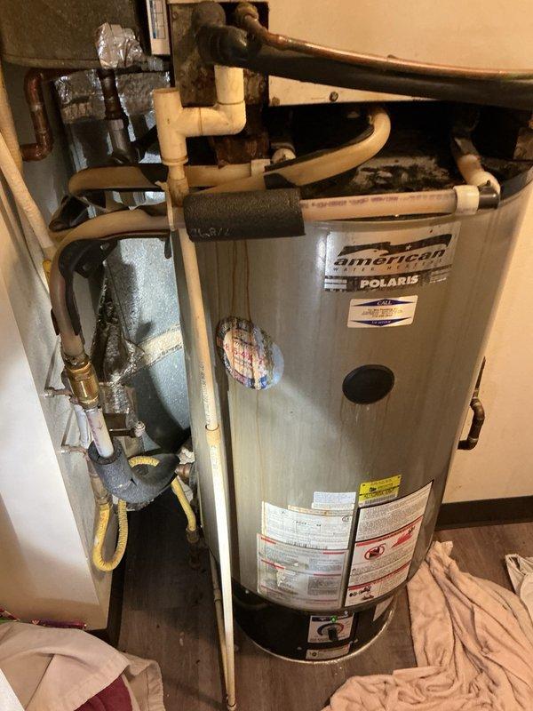 Responded to no hot water call on electric American Polaris water heater system with integrated air coil assembly. Upon inspection, discovered significant leaking from the air coil unit mounted on top of the water heater, with visible moisture and condensation present on connected piping. Confirmed complete loss of hot water functionality. Documented system configuration including all plumbing connections, ductwork, and air handler components. Awaiting property management authorization and confirmation of replacement unit availability on-site before proceeding with repair or replacement recommendations.