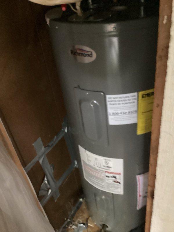 Responded to no hot water complaint affecting entire home. Upon inspection of Richmond brand tanked water heater, determined unit had no electrical power supply. Verified water heater installation with proper copper piping connections and seismic restraint strapping in place. Advised customer that electrical issue requires licensed electrician to diagnose and restore power to unit before water heater can operate.