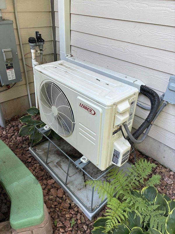 Responded to no cooling complaint on Lennox mini-split system installed two years prior. Customer reported loud chipping ice sounds and ice formation at indoor unit. Upon arrival, found system freezing up almost instantly during operation. Recovered refrigerant from system, pulling out 1 lb when factory charge specification is 2 lb 9 oz, indicating significant undercharge. Performed leak detection and identified refrigerant leak at flare connection on condenser unit. Removed and remade flare connections, cleaned excessive pipe dope and nylog residue from previous installation off connection nuts. Pressure tested repaired connections and performed bubble test on all flares to verify leak-free joints. Evacuated system to proper vacuum levels, then recharged unit to factory specification of 2 lb 9 oz. Verified system operation with all parameters within normal range. Unit now cooling properly with no abnormal sounds or ice formation.