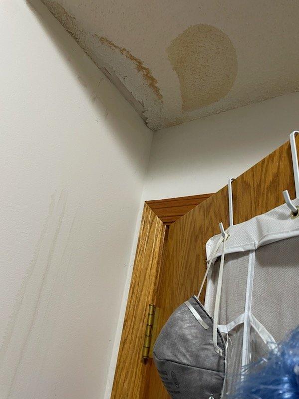 Responded to customer concern regarding brown spots and condensation appearing on furnace room ceiling. Conducted thorough diagnostic inspection of HVAC system including downflow furnace, return air ducts, refrigerant lines, venting, and fresh air return to identify potential moisture sources. Inspected return duct pathways and confirmed no signs of condensation or water accumulation within ductwork. Verified refrigerant line routing does not pass through affected ceiling areas. Confirmed downflow furnace configuration eliminates cold supply ducts as potential condensation source. Determined water damage and ceiling discoloration is not HVAC-related based on equipment location, duct routing, and absence of moisture in system components. Documented findings with photographic evidence showing water staining patterns on ceiling and confirmed HVAC equipment condition. Recommended plumbing department investigation with exploratory ceiling access to identify actual water source above damaged