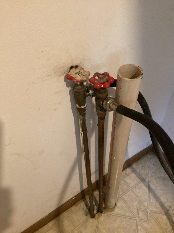 Responded to a leaking plumbing connection at the washing machine location. Upon inspection, found the laundry valves were old, badly corroded, and failing to seal properly, causing the leak. Replaced both laundry valves with new units to restore proper function and eliminate the water leak.