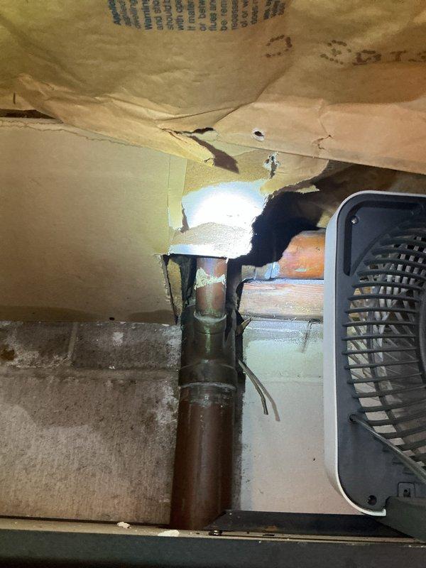 Responded to water leak emergency with moisture intrusion affecting multiple levels of the residence. Upon investigation, identified failed toilet wax ring seal in upper-level bathroom as primary source of water infiltration, causing damage to ceiling materials and visible moisture migration into garage area below. Observed significant corrosion and oxidation on copper supply lines passing through structural framing, indicating prolonged exposure to moisture. Documented extensive deterioration of surrounding building materials, including damaged subflooring and ceiling penetration points where plumbing fixtures penetrate. Replaced defective wax ring seal on toilet to restore proper watertight connection between fixture and drain flange. Inspected all associated plumbing connections for additional leaks or compromised seals. Coordinated with water damage restoration services for remediation of affected areas.