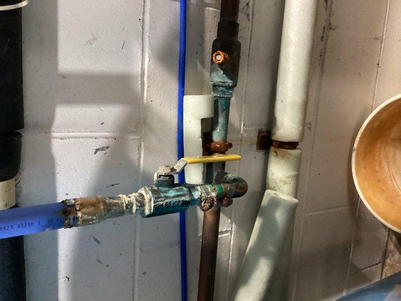 Responded to multiple plumbing issues throughout the residence. Replaced faulty Moen cartridge in upstairs shower valve to restore water flow and repair inoperable shower knob. Addressed leaking well line by repairing 1-inch copper pipe connection showing visible corrosion and oxidation. Inspected basement faucet with visible drip during irrigation system operation and verified water supply connections. Evaluated bathroom sink with crack and assessed faucet requiring replacement for future service. Inspected corroded shut-off valves and pipe fittings showing significant deterioration with rust and green patina buildup. All repairs completed without requiring main water shutoff to the property. Documented conditions of plumbing components including aged metallic valves, flexible connectors, and corroded pipe joints for maintenance records.