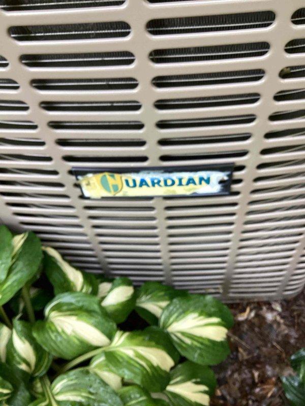 Completed air conditioning tune-up and maintenance on Guardian outdoor unit. Inspected system components, identified low refrigerant levels, and documented equipment condition with photos of both the outdoor condensing unit and associated indoor Weil-McLain furnace system.