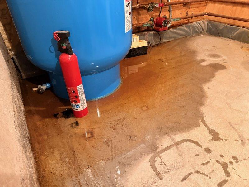 Responded to water leak complaint at residential property. Upon inspection, identified failed condensation pump with broken hose adaptor as source of water accumulation on basement floor. Water pooling was not originating from the Amtrol Boilermate indirect water heater or its pressure relief valve as initially suspected. Documented conditions with photographs showing water staining on concrete floor around equipment. Coordinated with HVAC contractor for condensation pump replacement and repair of drainage system. Equipment in utility room includes indirect water heater system with associated controls and plumbing connections.