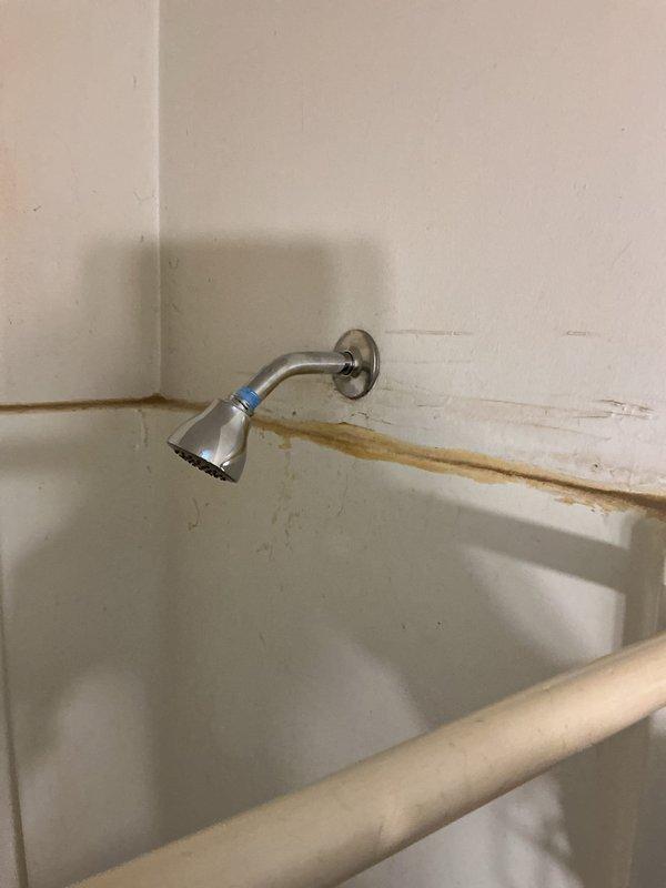 Replaced defective shower valve with new unit after determining rebuild cartridge was no longer available for existing model. Installed new shower valve trim and complete tub waste overflow assembly. Work was performed after tenant cleared access path to closet behind shower wall, which was necessary to access plumbing connections.