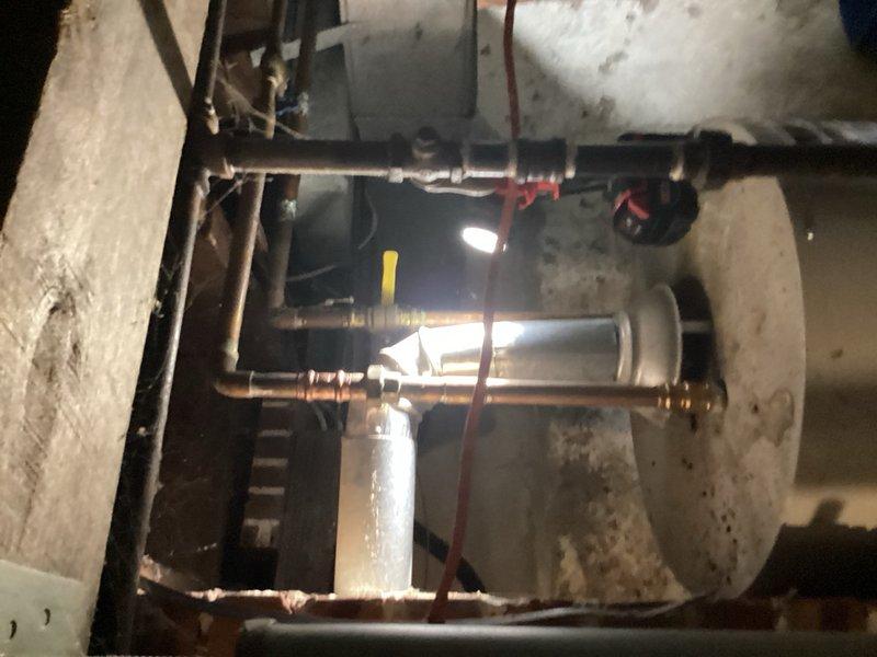 Removed and eliminated obsolete humidifier saddle valve from water supply line in basement utility area. The saddle valve was connected to the copper plumbing system near the water heater and was no longer in use following previous humidifier removal. Successfully disconnected the saddle valve, capped the penetration point in the copper pipe to restore proper water line integrity, and ensured all connections were secure with no leaks present upon completion.