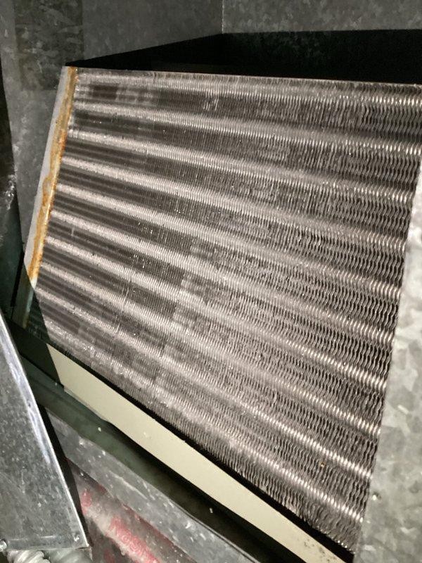 Responded to report of water leaking from furnace vent pipe. Upon arrival, no active water leak was observed. Investigated potential sources and determined condensation from air conditioning system operation and minor condensation from overhead cold water line were likely causes of small water accumulation previously observed. Checked refrigerant pressures on R22 system and found levels off but not critically low, ruling out coil freeze-up. System appears to be overfeeding refrigerant, noted replacement condenser installed in 2014 with unknown evaporator coil age. Documented equipment conditions with photos and provided quote for system corrections.
