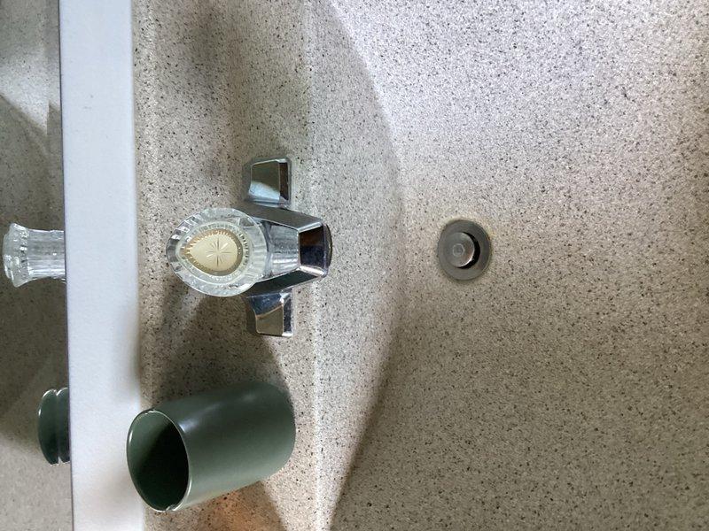 Completed comprehensive plumbing inspection for member, examining fixtures and water flow systems throughout the property. Inspected bathroom fixtures including sink basin, drain assembly, and shower/tub faucet controls to assess overall plumbing condition and discussed potential water softener installation for future consideration.