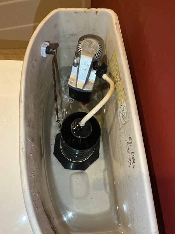 Responded to basement toilet leaking issue where homeowner attempted DIY repair of flapper and refill valve assembly without success. Upon arrival, found toilet components improperly installed with persistent leak from tank. Performed complete rebuild of toilet mechanism, including proper installation and adjustment of fill valve, flush valve assembly, and flapper system. Reconnected refill tube to overflow pipe, verified all compression fittings and supply line connections were secure, and tested system for proper operation and water seal integrity.