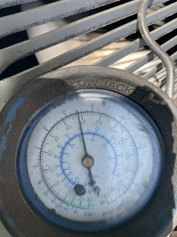 Responded to service call for AC unit not cooling properly and leaking condensation into furnace. Upon inspection, found minor condensate drain blockage which was cleared. Evaporator coil showed signs of freezing despite being relatively clean with adequate airflow. Measured system pressures and found suction pressure at 58 PSI, approximately 12 PSI below optimal specification for R22 refrigerant, indicating significant refrigerant loss. Inspected 30-year-old outdoor condenser unit and noted heavy dirt accumulation on coil fins. Made decision not to clean condenser coil due to concern that improved heat transfer would further drop suction pressure and result in complete system failure. Given the age of equipment (33-year-old furnace, 30-year-old AC unit), low refrigerant charge, and overall system condition, recommended system replacement consultation. Unit left operational with reduced cooling capacity pending replacement evaluation.