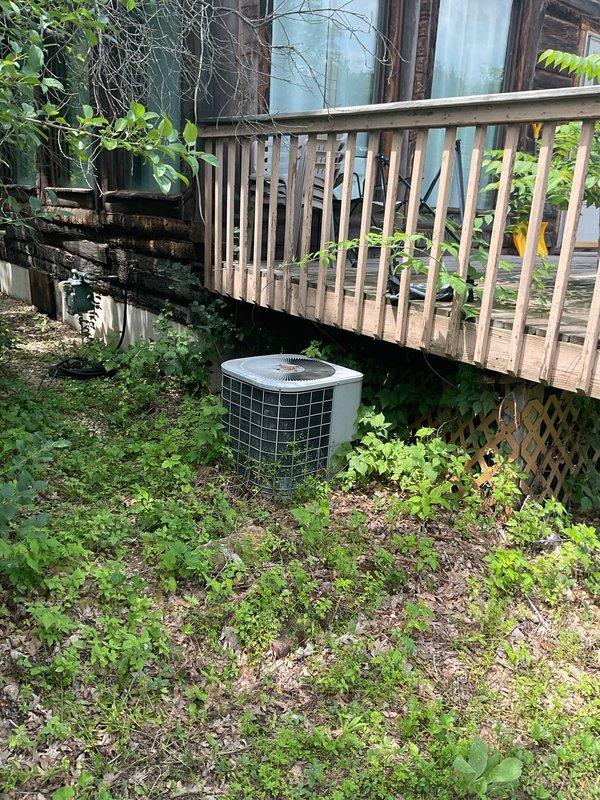 Responded to service call for AC unit not cooling properly and leaking condensation into furnace. Upon inspection, found minor condensate drain blockage which was cleared. Evaporator coil showed signs of freezing despite being relatively clean with adequate airflow. Measured system pressures and found suction pressure at 58 PSI, approximately 12 PSI below optimal specification for R22 refrigerant, indicating significant refrigerant loss. Inspected 30-year-old outdoor condenser unit and noted heavy dirt accumulation on coil fins. Made decision not to clean condenser coil due to concern that improved heat transfer would further drop suction pressure and result in complete system failure. Given the age of equipment (33-year-old furnace, 30-year-old AC unit), low refrigerant charge, and overall system condition, recommended system replacement consultation. Unit left operational with reduced cooling capacity pending replacement evaluation.