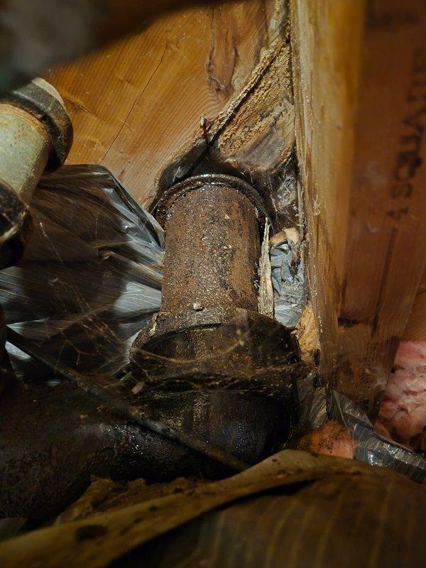 Responded to service call for non-functioning toilet with reported leak at base. Upon inspection, identified failed wax ring seal and deteriorated toilet flange causing water seepage onto bathroom floor. Documented extensive corrosion on flange and surrounding plumbing components, including mineral buildup on visible pipe connections beneath fixture. Provided estimate for complete flange replacement and toilet reinstallation with new wax ring seal to restore proper function and prevent further water damage to subfloor.