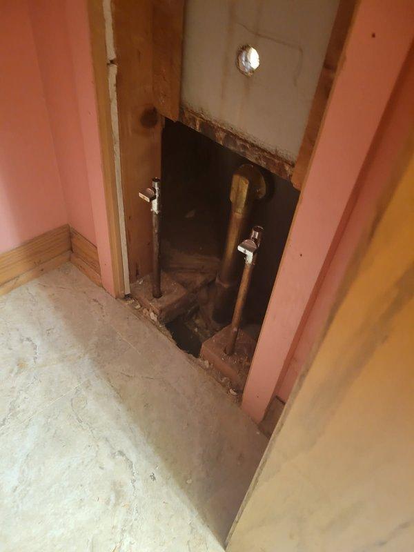 Responded to emergency no-water situation caused by broken tub faucet handle that resulted in valve assembly being ripped from wall during attempted repair. Water supply had been shut off to entire side of home, rendering multiple bathrooms inoperable. Removed damaged valve assembly, accessed plumbing through wall cavity, and installed homeowner-supplied Moen replacement valve. Restored water service to all affected fixtures including showers and toilets.