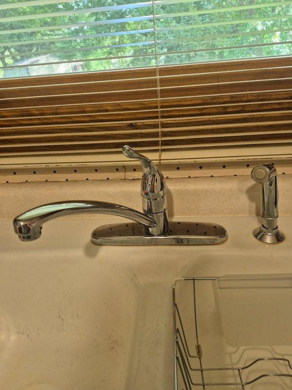 Responded to service call for leaking kitchen sink faucet. Upon inspection, identified multiple leak sources including a malfunctioning Moen side sprayer and a faulty strainer in the right sink compartment. Removed and replaced the defective side sprayer with new Moen unit, ensuring proper connection and seal. Installed new twist and lock strainer assembly in right basin to eliminate leak at drain. Tested all components for proper operation and verified no additional leaks present at faucet, sprayer, or drain assemblies upon completion.