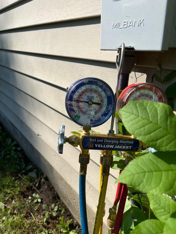 Responded to no cool call with outdoor unit squealing and condenser fan not operating. Upon arrival, found condenser fan motor locked up and seized. Freed up motor shaft to restore temporary operation and system cooling. Diagnostic testing revealed capacitor out of specification on hermetic terminal, contactor showing pitting and wear, and R22 refrigerant charge low. Connected manifold gauges to verify system pressures and refrigerant levels. Given the age of the unit and multiple component failures, provided estimates for condenser fan motor replacement to customer for consideration.