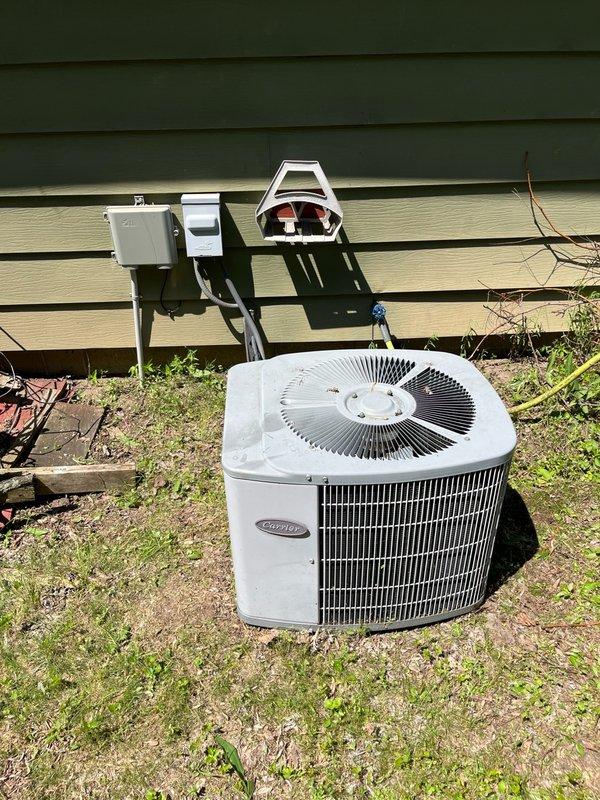 Responded to no cooling complaint on 12-year-old Carrier central air conditioning system with Goodman furnace. Customer had shut down unit after observing ice formation at outdoor unit. Performed diagnostic evaluation and found all electrical components operating within specifications with compressor, condenser fan, and blower motor engaging properly. System pressures indicated critically low R-22 refrigerant charge, confirming active leak in refrigerant circuit. Discussed findings with customer, explaining age-related concerns, R-22 phase-out implications, and repair cost considerations. Recommended obtaining repair estimates and replacement system pricing for comparison. Customer agreed to proceed with advisor consultation scheduled for following day.