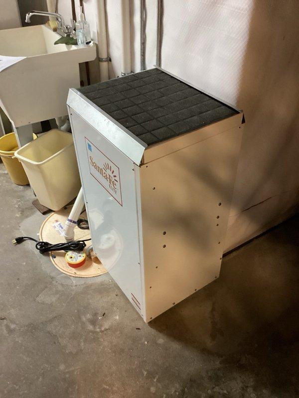 Responded to service call for 11-year-old Santa Fe Elite dehumidifier (P/N 4029720) with complaints of no warm discharge air, no water collection, and non-operational condensate pump while fan continued to run. Upon arrival, confirmed fan operation but compressor failure to start. Tested 45mf capacitor which read within acceptable range at 45.23mf. Performed diagnostic bypass of dehumidistat and defrost termination switch to supply direct power to compressor, which failed to start, confirming compressor failure. Advised that compressor replacement would exceed cost-effectiveness for unit of this age and condition. Recommended office follow-up for replacement unit quote or scheduling comfort advisor consultation for new equipment options.