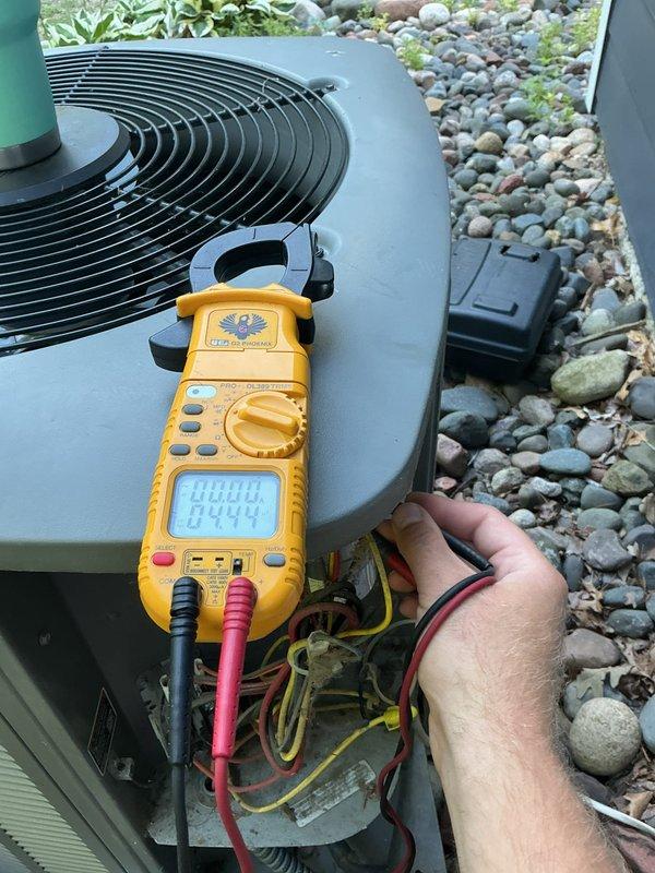 Responded to no cooling complaint on 18-year-old residential air conditioning system. Found high pressure switch had tripped; upon reset, condenser fan motor failed to operate. Diagnostic testing with multimeter confirmed condenser fan motor failure and weak capacitor. Replaced failed condenser fan motor and capacitor to restore system operation. Due to age of unit and repeated component failures, scheduled estimate for complete system replacement.