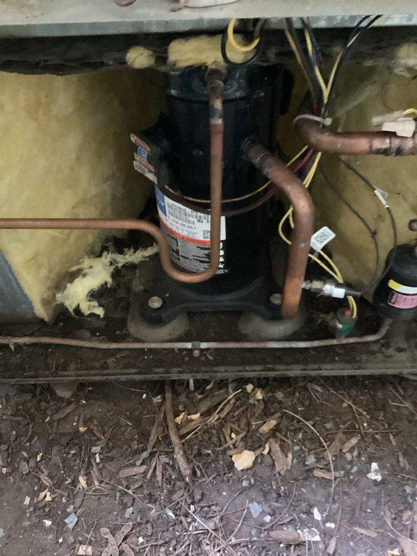 Responded to no cooling complaint on a Lennox central air conditioning system approximately 10 years old at a rental property. Upon inspection, discovered heavily soiled condenser unit with significant debris accumulation in base pan and deteriorated insulation in equipment compartment. Compressor was overheated due to system restriction affecting refrigerant flow, preventing proper cooling operation. Diagnosed refrigerant restriction causing compressor failure and loss of cooling capacity. Provided estimate for complete system replacement due to age and extent of mechanical failure.