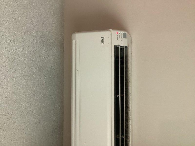 Responded to service call for 15-year-old mini split system reported as not cooling. Upon inspection, found indoor unit operating with no error codes displayed on control board. System was set to Dry Mode, which cycles on and off to dehumidify rather than provide continuous cooling—confirmed this is normal operation for that mode setting. Cycled unit through cooling mode and performed operational check of outdoor unit. Verified refrigerant levels and confirmed system operating within normal parameters. Replaced batteries in remote controller. Identified mold and buildup on indoor unit requiring deep cleaning service and provided estimate for that work. Left system running in Dry Mode per existing settings.