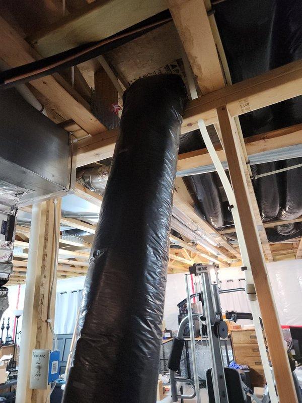 Responded to service call regarding disconnected insulated flexible ductwork hanging near furnace in basement following IAQ installation. Upon inspection, identified the hanging duct as an extra fresh air intake that was not part of the active HVAC system. Documented existing conditions with photographs showing the redundant intake ductwork, PVC condensate drainage system, furnace unit, and surrounding mechanical installations in the utility area.