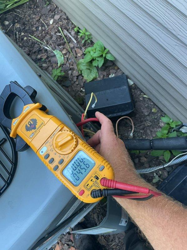 Responded to callback for AC not cooling and water leaking from furnace. Upon arrival, found outdoor unit's self-diagnostic tool had tripped. Reset system and performed comprehensive testing of all components using clamp meter to verify electrical readings within manufacturer specifications. Confirmed refrigerant charge slightly elevated but within acceptable range. Identified primary issue as condensate drain pan overflow due to improperly oriented drain fitting preventing water discharge. Removed drain piece from pan, reoriented fitting 180 degrees to establish proper drainage flow, and verified condensate now draining correctly. Tested system operation through complete cooling cycle. All components functioning properly, AC operational, and drainage issue resolved.