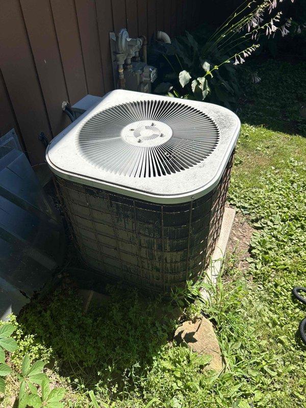 Performed routine maintenance visit for combined A/C and furnace tune-up on system with air conditioner over 10 years old. Customer reported inadequate cooling during hotter weather. Upon inspection, found condenser coil heavily soiled with debris, restricting airflow and reducing system efficiency. Performed coil cleaning by rinsing condenser, which improved temperature split from 14° to 16° across the evaporator coil. Verified proper refrigerant charge with evaporator coil sweating uniformly to suction line. Completed system evaluation with no additional deficiencies identified. Advised homeowner of unit's age and recommended planning for future equipment replacement due to expected service life considerations.