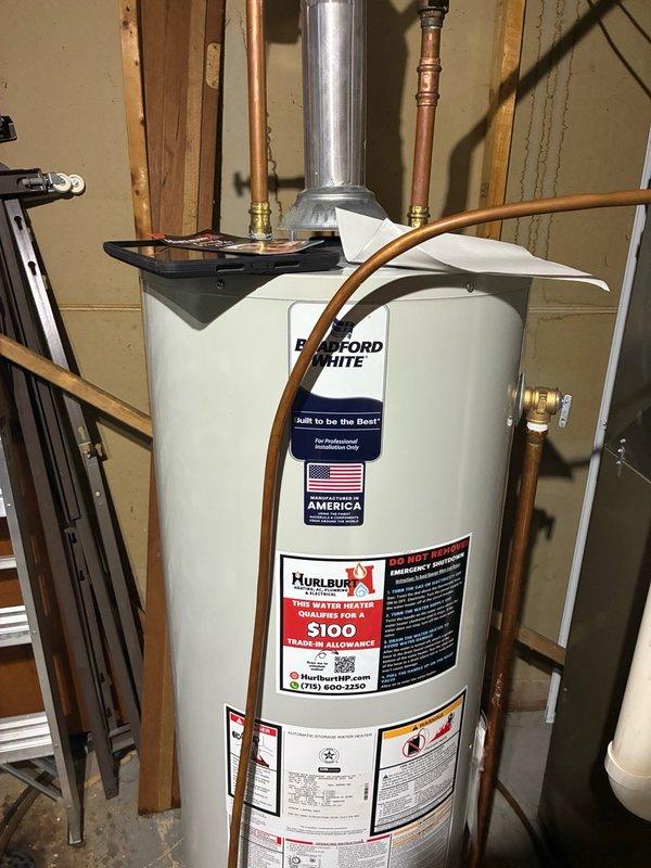 Responded to service call for complete loss of hot water in residential property. Upon inspection, diagnosed faulty thermostat on existing tanked water heater that was preventing proper heating operation. Due to thermostat failure and unit condition, performed complete water heater replacement. Installed new Bradford White residential tank-type water heater with proper venting through galvanized flue pipe. Connected hot and cold water supply lines using copper piping with brass fittings and shutoff valves. Positioned drain pan beneath unit for leak protection. Tested all connections for proper operation and verified hot water delivery throughout home upon completion.