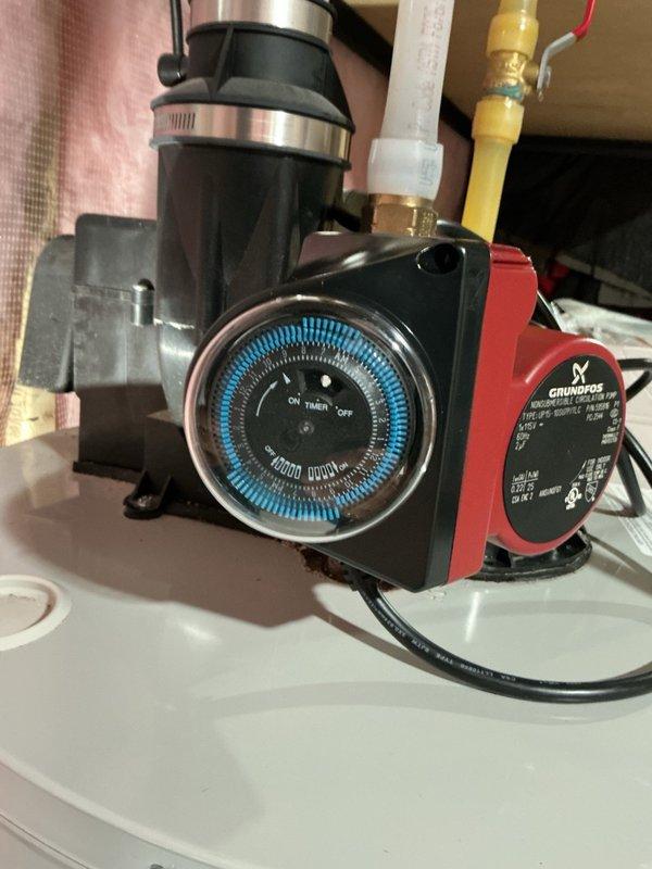 Removed and disposed of a corroded and leaking hot water recirculation pump from the residential water heater system. Installed a new Grundfos recirculation pump with timer control, ensuring all connections were properly secured to existing piping infrastructure. Bled all hot water lines throughout the system to remove air pockets and verified proper circulation and pump operation. During inspection, identified a corroded nipple fitting on the water heater outlet that will require future monitoring and potential replacement. Tested the complete system for leaks and confirmed the new pump was cycling correctly according to timer settings. Installation includes a 1-year parts and labor warranty. Customer was advised of the corroded fitting condition but declined additional repairs at this time.