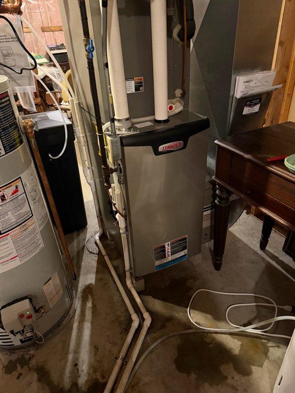 Removed and properly disposed of existing residential water heater from basement utility area. Installed new 40-gallon natural gas power vent water heater in same location. Connected copper supply lines to top of unit and verified all inlet/outlet connections for proper seal. Installed required PVC venting system for power vent exhaust. Configured gas line connection and tested for leaks using approved methods. Installed temperature and pressure relief valve with proper discharge piping. Filled tank, purged air from lines, and fired unit to verify proper ignition and burner operation. Tested all safety controls including high limit switch and thermal cutoff. Verified adequate combustion air supply and proper venting draft. Inspected surrounding area for water damage on concrete floor and confirmed no active leaks from new installation. All connections secured and system operational per manufacturer specifications.
