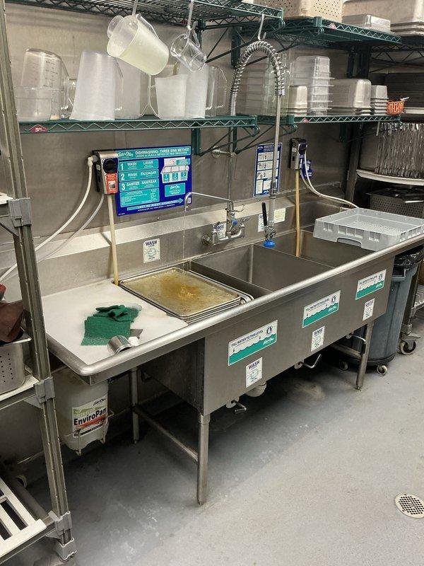 Completed re-siliconing work throughout commercial kitchen and restroom facilities. Removed deteriorated silicone and applied fresh commercial-grade sealant around all hand sinks, toilets, mop sink, three-compartment dishwashing sink, and cold prep sink. Addressed water retention issue in triple sink by properly sealing all seams and joints around stainless steel basins, ensuring watertight integrity for proper dishwashing operations.