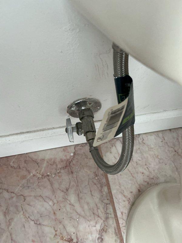 Responded to a service call for a malfunctioning toilet shut-off valve that would not properly turn off the water supply. Upon diagnostic inspection, determined that the full port shut-off valve's internal gaskets had deteriorated and disintegrated, preventing proper valve operation. Removed the failed chrome-plated shut-off valve from the wall-mounted water supply line and installed a new replacement valve with mushroom-shaped handle. Connected the braided stainless steel flexible supply line from the toilet tank to the new shut-off valve and verified complete functionality and proper water shut-off capability. Tested the installation to ensure leak-free operation and confirmed the valve now operates correctly to control water flow to the fixture.