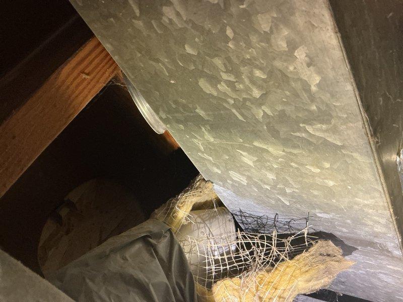 Responded to no airflow complaint affecting four upstairs bedrooms. Diagnosed inadequate blower speed setting when system operated in fan-only mode—adjusted blower speed from low to mid-high setting, which restored airflow to three of four bedrooms. Investigated master bedroom supply vent with zero airflow and discovered supply vent was incorrectly connected to return ductwork rather than supply trunk line, confirmed by observing spider webs being drawn inward instead of expelled outward. Unable to trace ductwork routing from basement due to concealed chase with no access points. Located and repaired two disconnected duct sections in basement using foil tape to restore proper connections. Documented misrouted master bedroom ductwork requiring replacement to establish proper supply air path—recommended scheduling estimate for ductwork rerouting and installation of access panel for future serviceability.