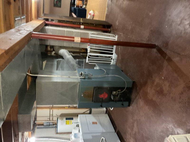 Responded to service call for air conditioning system reportedly running continuously during extreme heat conditions with outdoor temperatures approaching 100°F. Upon arrival, found residence maintaining setpoint of 70°F with indoor temperature matching thermostat setting. Inspected 2003 Rheem condensing unit utilizing R-22 refrigerant and identified partially blocked condenser coil restricting airflow. Performed condenser coil cleaning by rinsing exterior coil to restore proper heat transfer efficiency. Cycled system and measured supply air temperature split at 22°F, confirming adequate cooling capacity and normal refrigerant charge. Verified compressor operation, fan motor function, and overall system performance within manufacturer specifications. No mechanical defects or refrigerant leaks detected during inspection. Educated customer on expected extended runtime characteristics during peak ambient conditions, particularly for aging R-22 equipment operating at design limits. System 