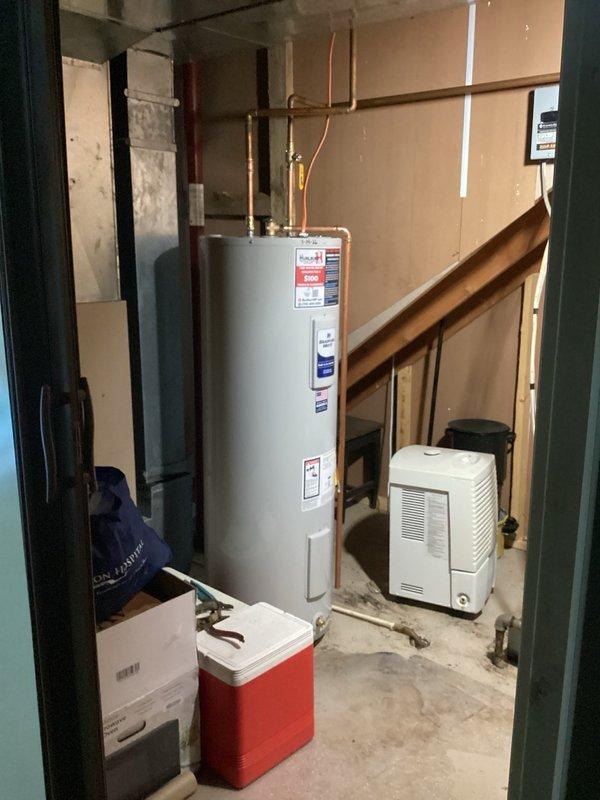 Completed full replacement of 50-gallon electric water heater in basement utility area, including draining and removal of existing unit and installation of new unit with basic connection materials and permit. Replaced failing 20-gallon well water pressure tank assembly to maintain proper water flow and prevent pump motor failure, utilizing existing tee assembly connections. Installed 1-inch inline spin-down whole house sediment filter system to capture sediment and particulate matter, improving water clarity and protecting plumbing fixtures from mineral deposits and staining. All copper piping connections secured and tested for proper operation. Systems verified operational upon completion.