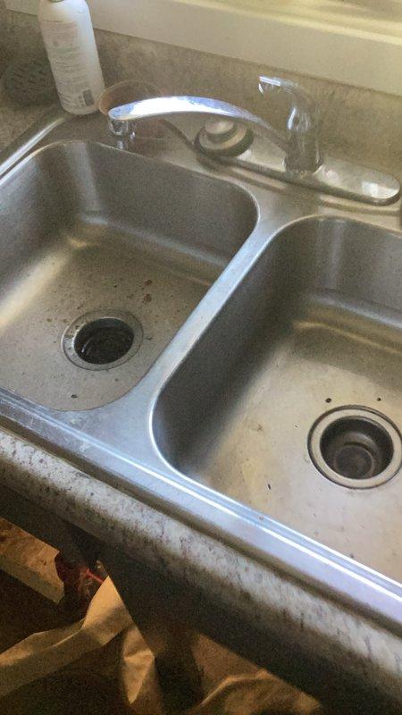 Responded to service call for slow-draining kitchen sink with suspected garbage disposal malfunction. Upon inspection, determined the two-inch drain line was severely clogged, causing water to back up in both basins of the double-basin stainless steel sink. Snaked the kitchen drain line three times to clear the obstruction and restore proper drainage. Verified garbage disposal remained in working order and did not require replacement.