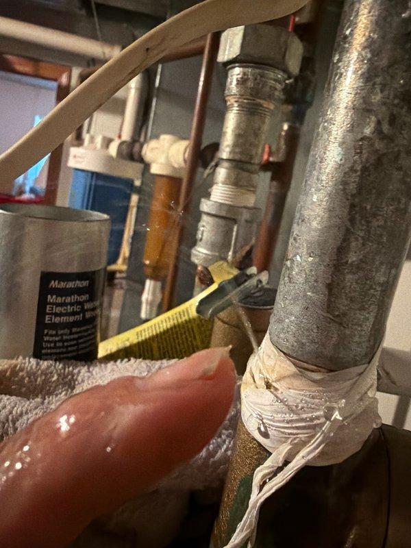 Responded to water leak emergency at Marathon water heater. Upon inspection, identified leak originating from vacuum relief tee at top of unit, not bottom as initially reported. Temporarily secured affected piping connections and documented extensive frost buildup on surrounding plumbing components indicating potential insulation issues. Ordered replacement vacuum relief tee for Marathon unit and scheduled return visit to complete installation and restore system to proper working condition.