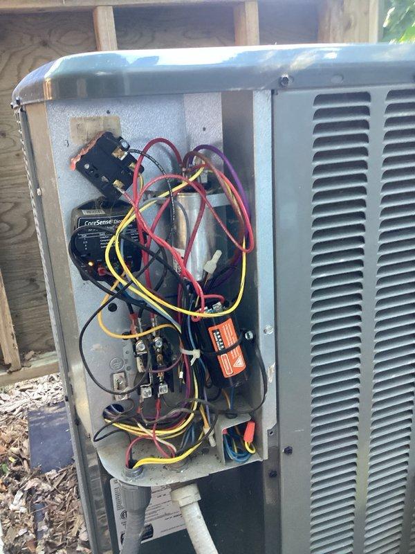 Responded to no cooling complaint on brand new air conditioning system. Found outdoor condenser unit not operating despite thermostat calling for cooling. Diagnosed issue by checking contactor and high voltage supply, discovering absence of 24V control voltage to contactor. Traced low voltage wiring and identified loose wire connections at energy saver switch as root cause. Reconnected and secured all low voltage wiring at energy saver switch, restoring proper control circuit continuity. Verified system operation, checked refrigerant charge levels and temperature split across evaporator coil. System returned to normal cooling operation with all components functioning properly.