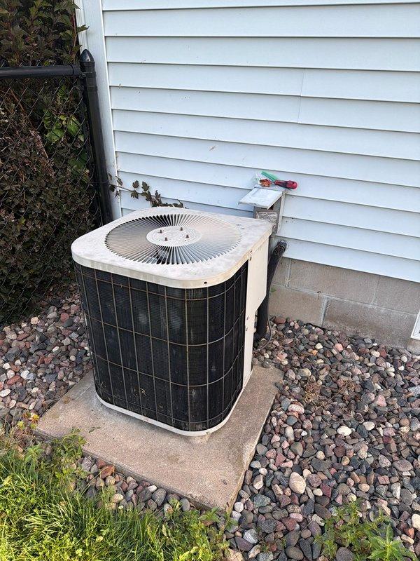 Responded to no cooling complaint on 10+ year old R22 system where customer reported loud buzzing noise before condenser failure. Diagnosed and replaced failed capacitor, restoring condenser operation. Verified refrigerant charge levels were within acceptable range. Installed customer-supplied air filter, cleared condensate drain line, and confirmed condenser coil cleanliness. Advised customer of system age and R22 refrigerant phase-out, recommending against major future repairs due to equipment obsolescence and oil furnace configuration. Unit tested and left operating normally.