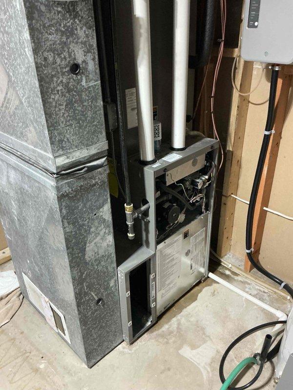 Responded to water leak complaint from downstairs HVAC air handler unit. Upon inspection, identified clogged evaporator coil condensate drain line as source of water backup. Cleared obstruction from drain line and removed accumulated dust and debris from drain pan to prevent future clogs. Flushed drain line thoroughly with water to ensure complete clearance and verify proper drainage flow. System now draining properly with no backup occurring.