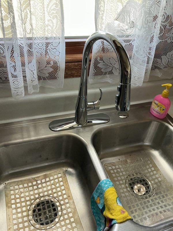 Responded to service call for malfunctioning kitchen faucet in residential home. Upon inspection, determined existing faucet required replacement due to failure. Removed old kitchen faucet assembly and installed new chrome pull-down single-handle faucet unit on double-basin stainless steel sink. Installed new angle stops on water supply lines to ensure proper shut-off capability and code compliance. Tested new faucet installation for proper operation, water flow, and verified no leaks at connections or supply lines. All plumbing connections secured and functional upon completion.