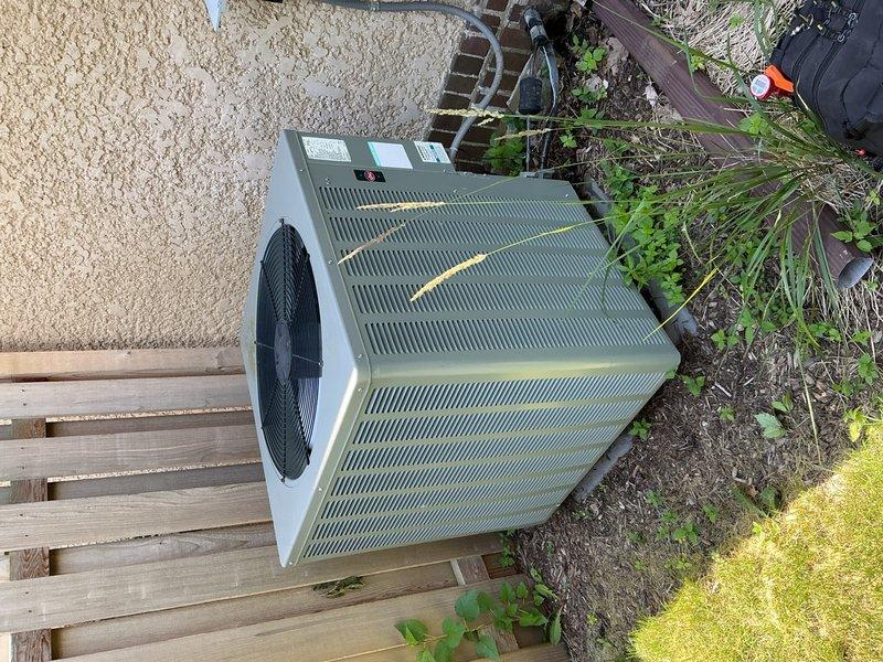 Responded to no cooling complaint on R-22 refrigerant system installed in 2008. Diagnosed system as low on refrigerant with suction line frost buildup, low side pressure at 51 PSI with 3.9°F superheat and 27.2°F vapor saturation temperature, and high side pressure at 221 PSI with subcooling at 221°F and liquid saturation at 108°F. Found outdoor condenser coils heavily clogged with cottonwood debris restricting airflow. Advised homeowner to clean coils and scheduled estimate appointment for system replacement due to age and R-22 refrigerant phase-out considerations.